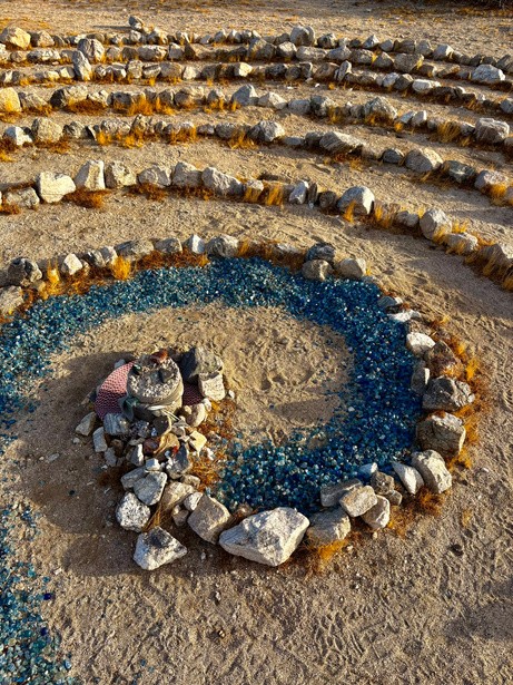 An overhead view of a stone labyrinth inlaid with blue glass